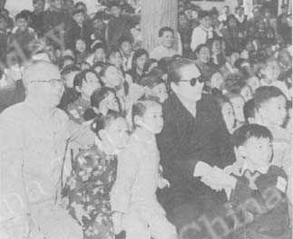 
一六六三年五月一日国际劳动节，当时的北京副市长吴晗（左）和宋庆龄副主席在北京景山公园同孩子们一起观看演出。
吴化学摄
