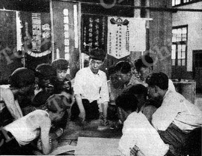 
Ma Heng-chang and his team discuss production plan. The banners behind them were won in nationwide work competitions.
